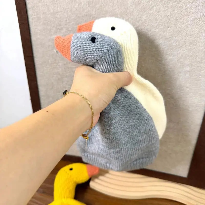 Hand holding grey and white duck beanies